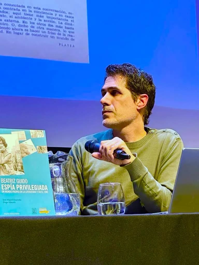 Diego Sabanés presentando el libro «Beatriz Guido, espía privilegiada», micrófono en mano.